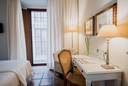 a hotel room with a desk and a bed and a window at Palacio De Los Navas in Granada