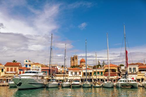 un groupe de bateaux amarrés dans un port avec des bâtiments dans l'établissement Hotel Aegina, à Égine