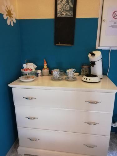 a white dresser with cups on top of it at Gästezimmer am Deister in Springe