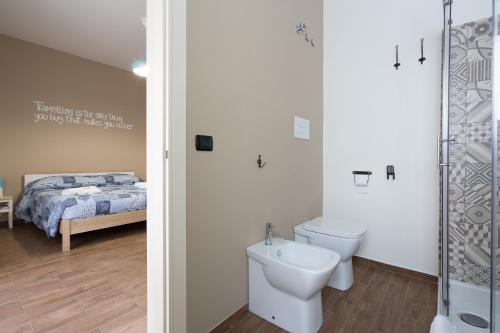 a bathroom with a toilet and a bed at Pura Vida Barocca in Ragusa