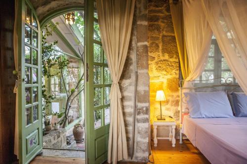 a bedroom with a bed and a window at Oliveyard Stone Built House- with pool non chlorin in Koskinou