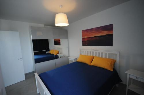 a bedroom with a blue bed with yellow pillows at Appartamenti porta mare in Otranto