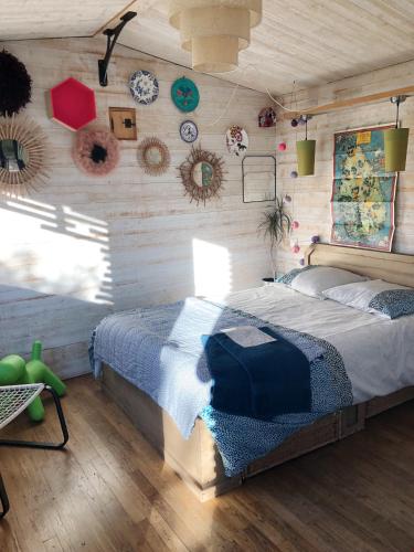 une chambre avec un lit et un mur en bois dans l'établissement Les cabanes de Vallis Clausa, à Saumane-de-Vaucluse