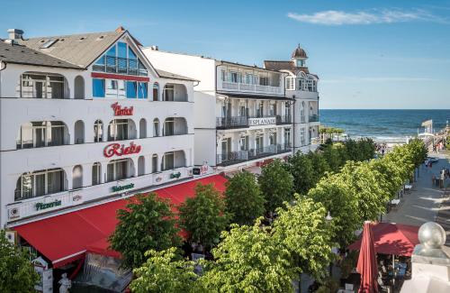 ein Hotel am Strand mit dem Meer im Hintergrund in der Unterkunft Hotel Esplanade & Aparthotel Rialto in Binz