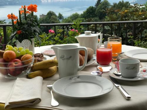 een tafel met borden eten en fruit erop bij Albergo Rusall in Tremezzo