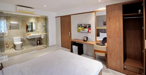 a bedroom with a bed and a desk and a bathroom at For You Hotel in Nha Trang