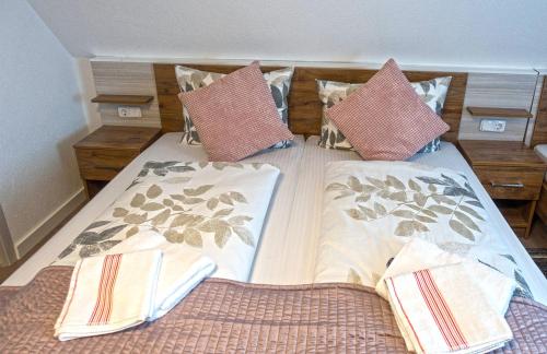 a bed that has two pillows on it at Hotel Zum Böhmegrund in Bad Fallingbostel