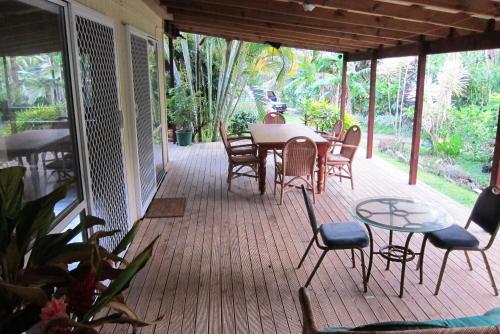 a screened in porch with a table and chairs at Raina Holiday Accommodation in Rarotonga