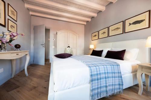 a bedroom with a large white bed and a desk at Isola Bella Apartments - Via del Voltone in Stresa