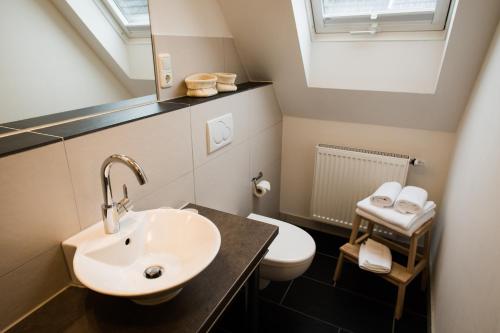 a bathroom with a sink and a toilet at Pension Kerckenhof in Xanten