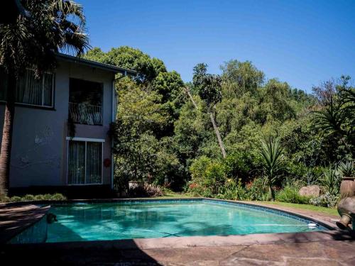 a swimming pool in front of a house at Africa's Eden Guesthouse in Pietermaritzburg