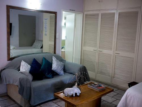 a living room with a blue couch and a mirror at Africa's Eden Guesthouse in Pietermaritzburg