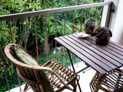 a wooden table and a chair on a balcony at Africa's Eden Guesthouse in Pietermaritzburg