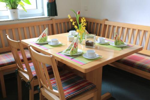 a wooden table with cups and saucers on it at Weinstube Schwalbennest in Karlstadt