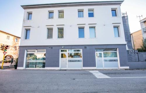 a white building with white doors on a street at A casa di V-Ale in Treviso