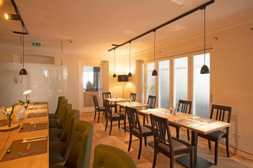 a dining room with long tables and chairs at Hotel & Gutsgasthaus Köberle in Lindau