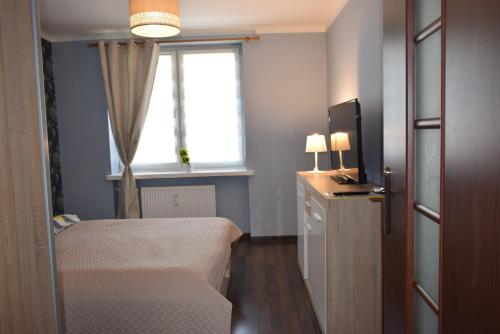 mały pokój z łóżkiem i oknem w obiekcie Pałacowa Condominium w mieście Białystok