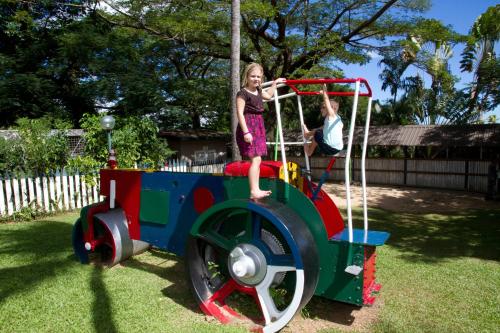 a young girl is standing on a train playground at Tanoa Skylodge Hotel in Nadi