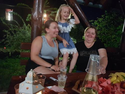 a group of three women sitting around a table with a little girl at Etno domaćinstvo Milenković in Despotovac