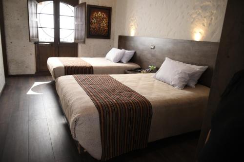 a hotel room with two beds and a window at Acolpacha Tambo Boutique in Arequipa