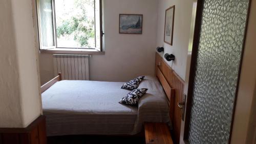 een kleine slaapkamer met een bed en een raam bij Casa Sauro in Menaggio