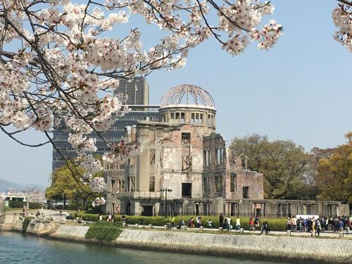 an old building withakura trees in front of a building at Luxes Hiroshima2030 ラクセス ヒロシマ2030 in Hiroshima