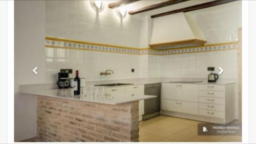 cocina con armarios blancos y encimera en Torres de Valencia Apartments, en Valencia