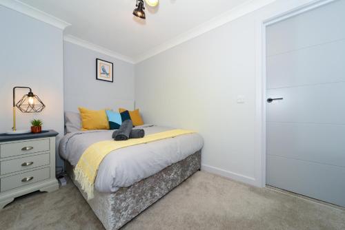 a bedroom with a bed and a dresser and a door at Beautiful Apartment near Bournemouth, Poole & Sandbanks in Poole