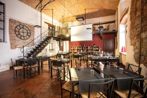a restaurant with tables and chairs and a staircase at Palazzo Centro Alloggi Vacanza in Nizza Monferrato