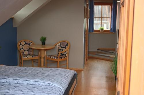 a bedroom with a bed and a table and chairs at Pension Kärnten in Seeboden