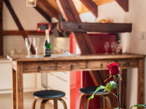 a wooden table with a bottle of champagne and two stools at Penzion Na barokní cestě Wellness & Spa in Plasy