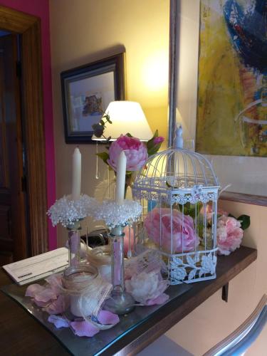 un tavolo con una gabbia per uccelli e fiori di Posada Rural Entrecomillas a Comillas