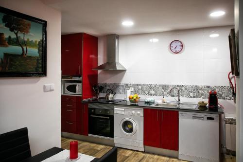 een keuken met rode kasten en een wasmachine bij Casa Rural Ruplas in Villalba de Adaja