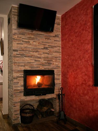 a fireplace with a tv on a brick wall at Casa Rural Ruplas in Villalba de Adaja