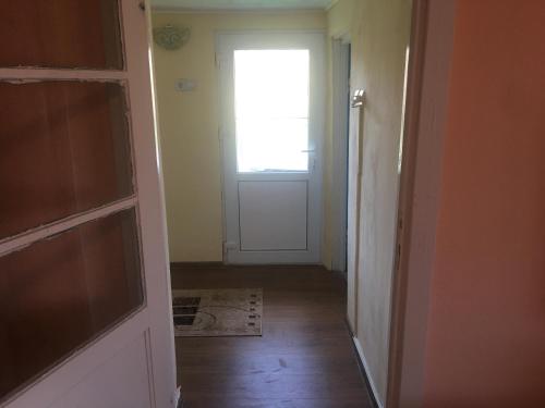 an empty hallway with a door and a window at Vila la Izvorul Putinei in Haţeg