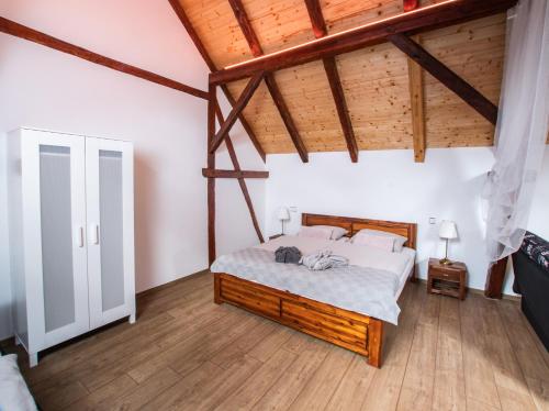a bedroom with a bed in a room with wooden ceilings at Penzion Na barokní cestě Wellness & Spa in Plasy