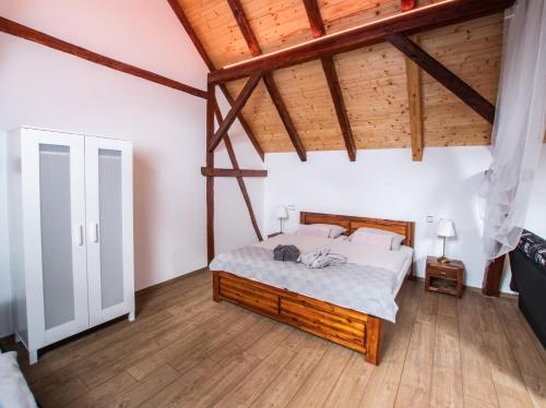 sypialnia z łóżkiem w pokoju z drewnianym sufitem w obiekcie Penzion Na barokní cestě Wellness & Spa w mieście Plasy