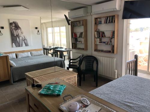 a living room with two beds and a table at Naturiste Port Soleil avec piscine in Cap d'Agde