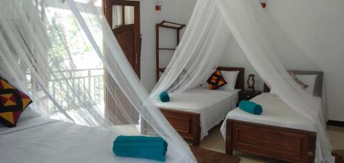 Un dormitorio con dos camas y una ventana. en Liyara Home Stay, en Sigiriya