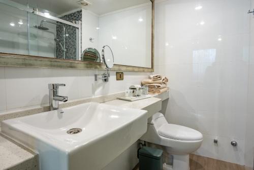 a white bathroom with a sink and a toilet at Hotel Libertador in Santiago