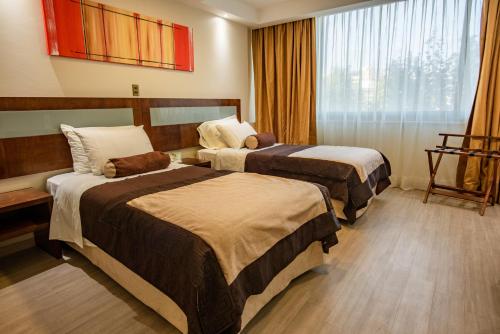 a hotel room with two beds and a window at Hotel Libertador in Santiago