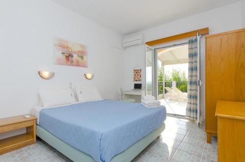 een slaapkamer met een blauw bed en een balkon bij Natural Blue Green Apartment in Almiros strand
