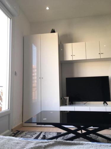 un salon avec une grande armoire blanche et une télévision dans l'établissement Lovely Apartment in Mention French Riviera, à Menton