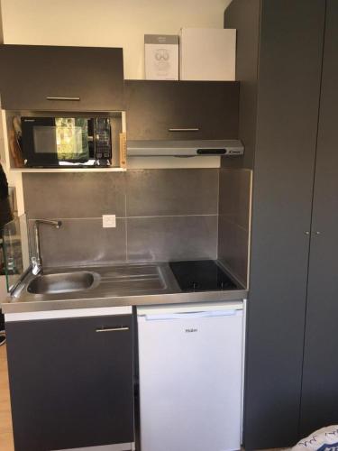 a small kitchen with a sink and a microwave at Lovely Apartment in Mention French Riviera in Menton