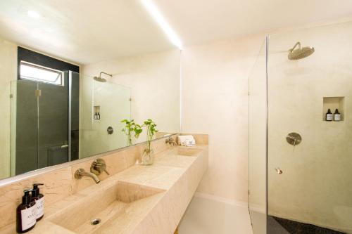 沙由利達的住宿－Avela Boutique Hotel，一间带两个盥洗盆和淋浴的浴室