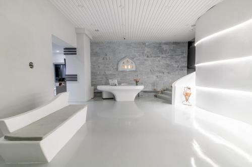 uma casa de banho branca com uma parede de pedra e um lavatório. em Byzantio City Hotel em Tinos Town