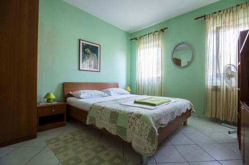 una camera con letto e specchio di Apartments Sunčica a Mali Lošinj (Lussinpiccolo)