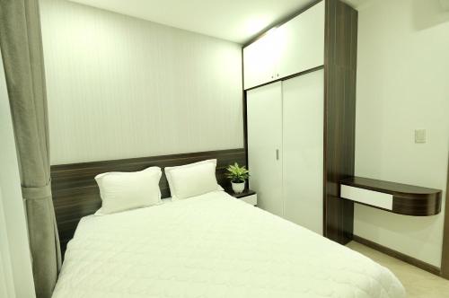 a bedroom with a white bed and a mirror at Stay in Nha Trang Apartment in Nha Trang