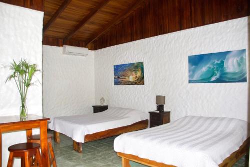 a room with two beds and a table at Vida Hermosa in Playa Hermosa