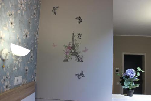 a room with butterflies on the wall and a vase of flowers at Provance Guest House in Tsemdolina